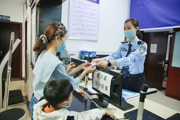 林女士領(lǐng)取兒子的第一張居民身份證。重慶市公安局治安管理總隊(duì)供圖