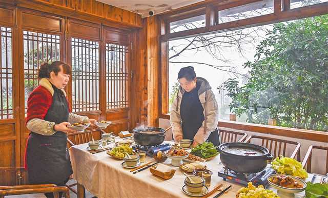 一月十五日,縉云村,“山之語”民宿老板周紅(右)正在為客人準(zhǔn)備美食。