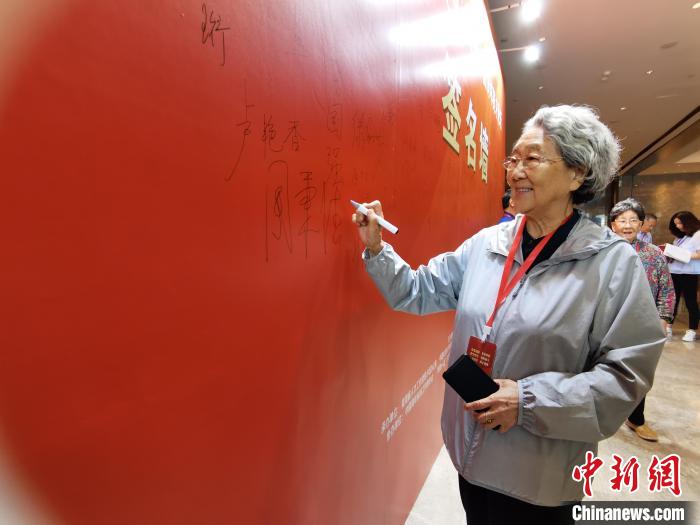 圖為中國新聞社原副社長周秉德簽字留念?！∑钤鲚?攝