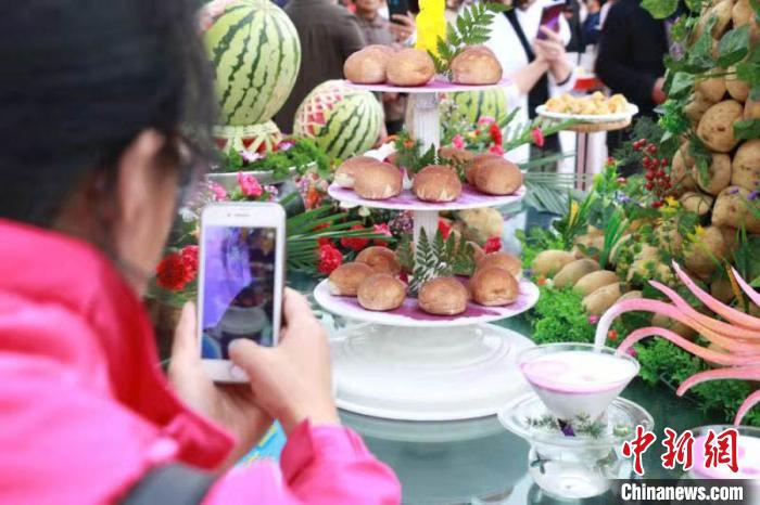 民眾利用手機(jī)給展示臺(tái)上優(yōu)質(zhì)馬鈴薯拍照。(資料圖) 張婧 攝